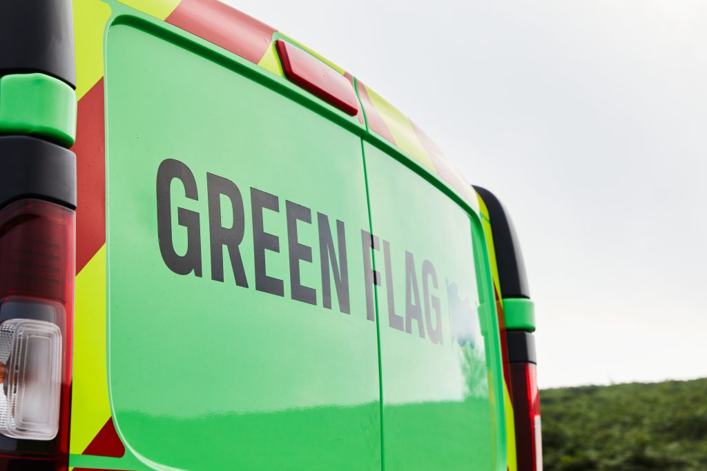 一辆绿色货车的后面有“绿旗”的字样