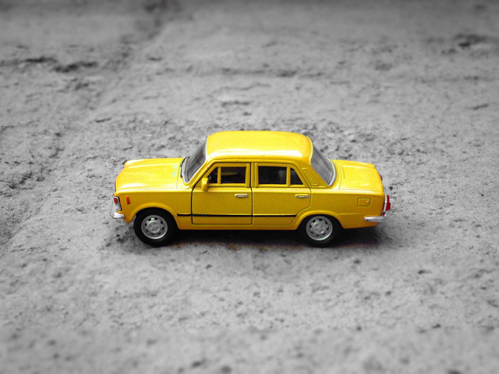 黄色的玩具车停在灰色的地面上